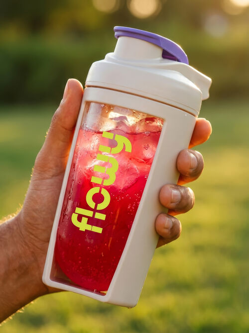 Hand holding a Flowy shaker filled with iced lemon lime