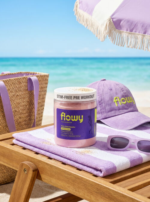 Flowy tub on a beach towel with a sun hat and tote