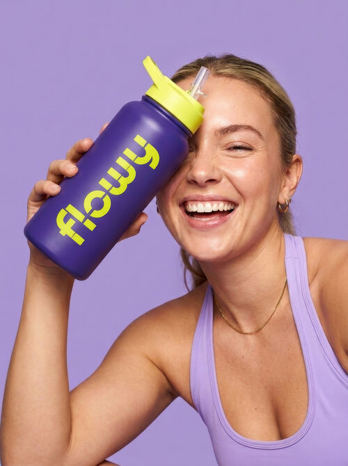 Smiling woman holding a Flowy water bottle